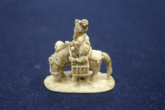 A Japanese carved ivory group of a family travelling with a donkey, height 43mm.